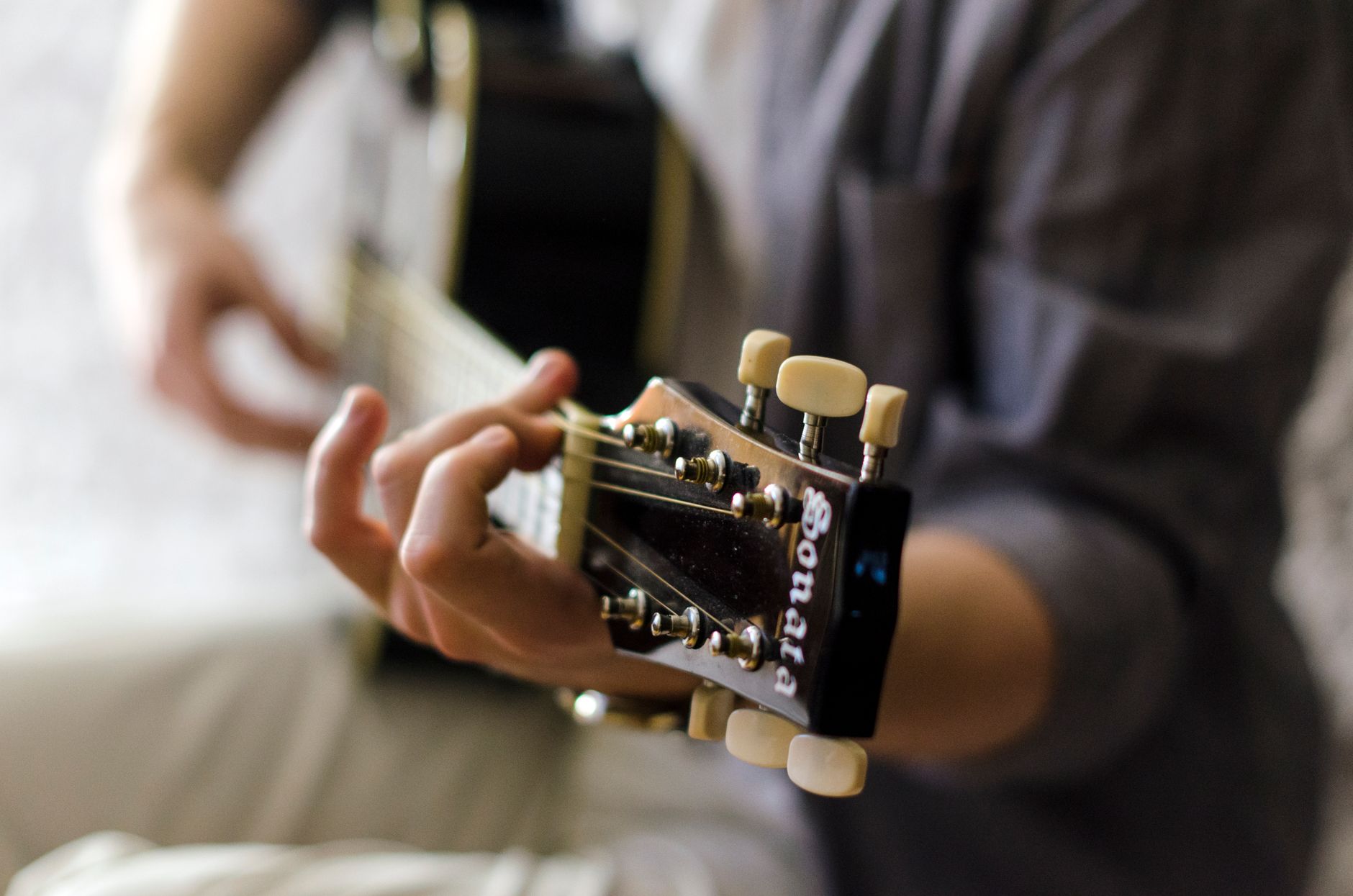L’accordeur d’instruments Google : fonctionnement, promesse et vrais usages — musicien accordant une guitare en ligne